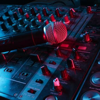 Night club, nightlife concept. Disco. Microphone on DJ remote. Neon red blue light